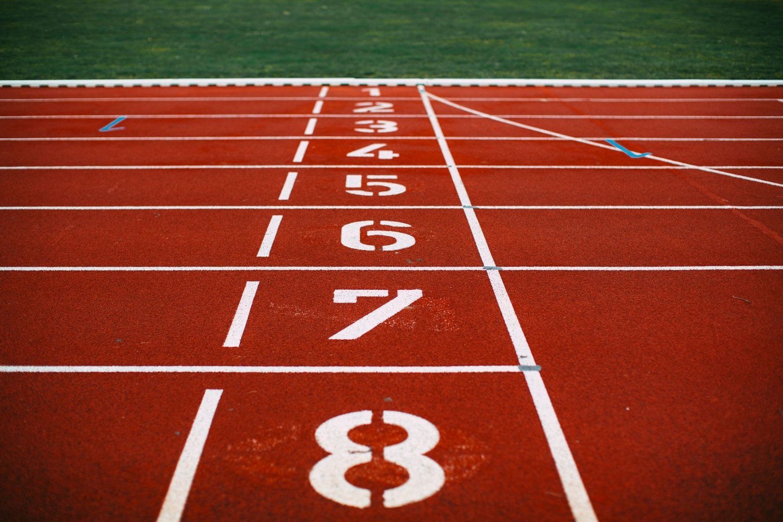 Numbered lanes 1 to 8 on a red running track at the start line.